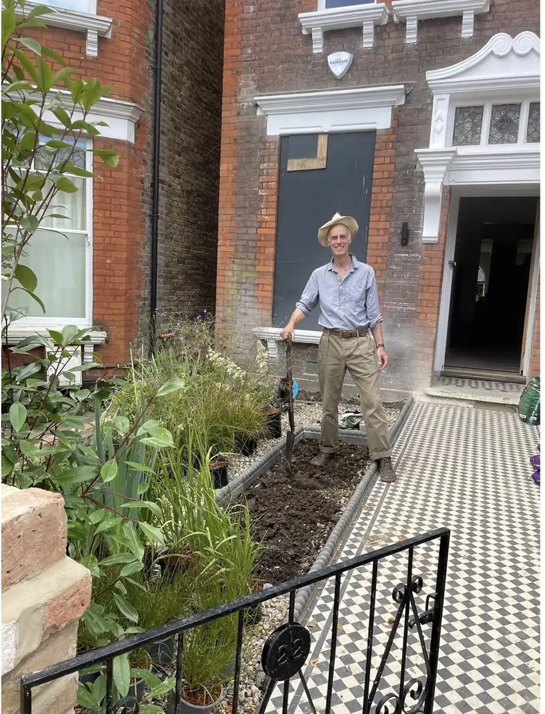 Will standing in a London front garden in a straw hat, holding a spade beside a newly dug border